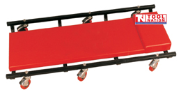 Creeper angled top view with red padded surface, headrest, black frame, and red casters