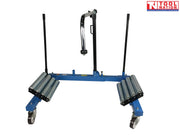 Angled front view of blue tractor wheel dolly with twin roller platforms, caster wheels, and central support arm