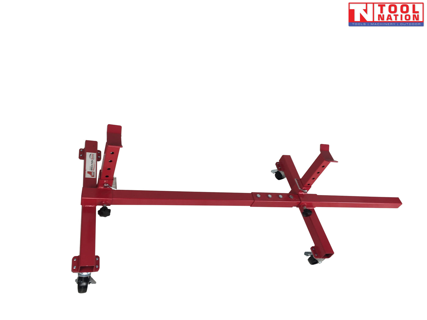 Angled side view of red mobile car axle dolly with adjustable support arms, center beam, and caster wheels