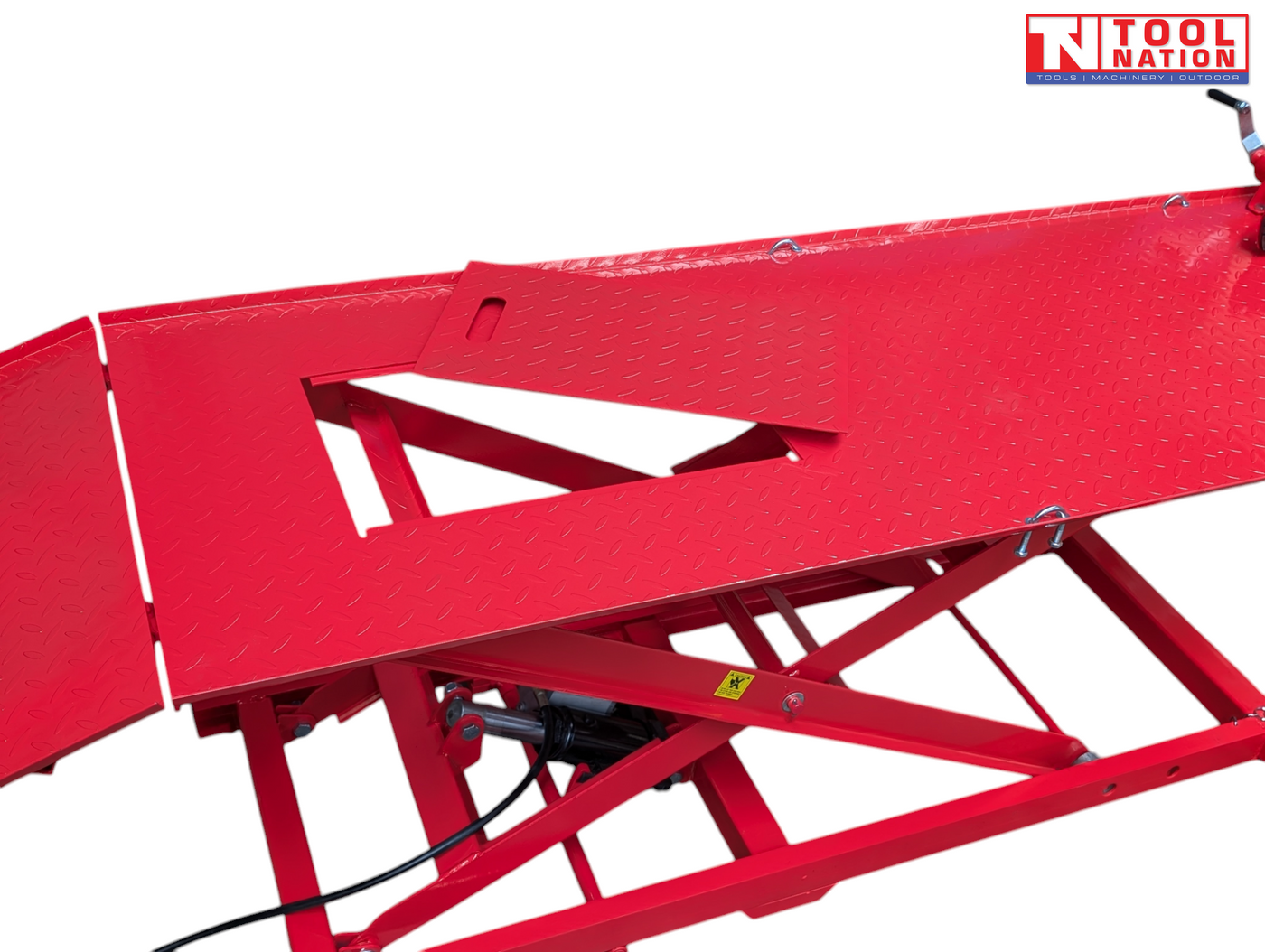 Close-up of the red lift platform showing the removable center service panel opening and part of the red scissor frame underneath.