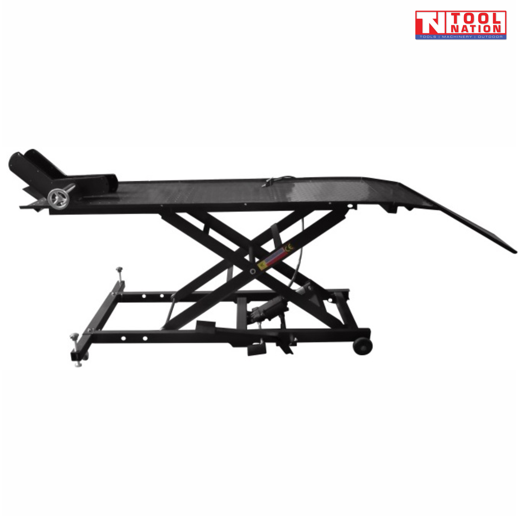 Side view of a black motorcycle lift with raised scissor frame, rear loading ramp down, front wheel chock, and base frame with small wheels.