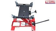 Front angled view of red hydraulic floor transmission jack with black saddle plate, safety chains, and handle
