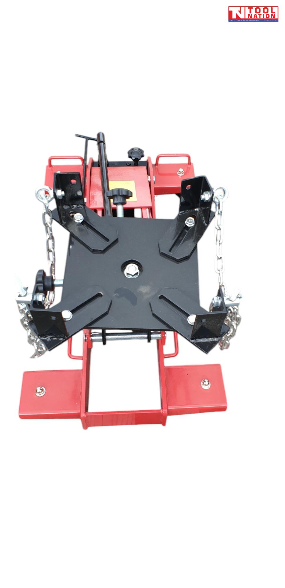 Top front view of red floor transmission trolley jack with black saddle plate, corner brackets, and safety chains
