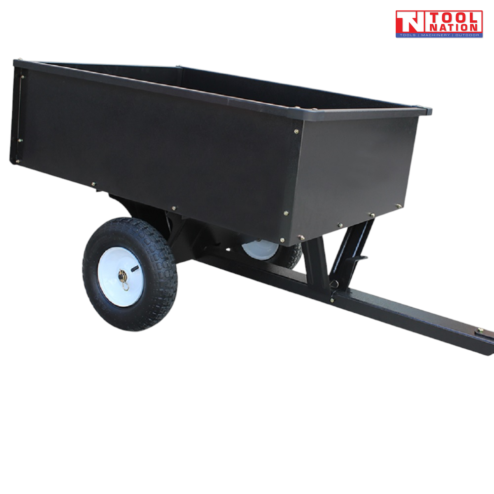 Black tow-behind steel dump cart shown from above with an open tray, long drawbar, hitch pin, two treaded tyres and Tool Nation logo.