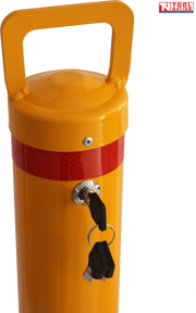 Close-up of a yellow removable bollard showing the top handle, red reflective band, key lock, hanging keys and Tool Nation logo.