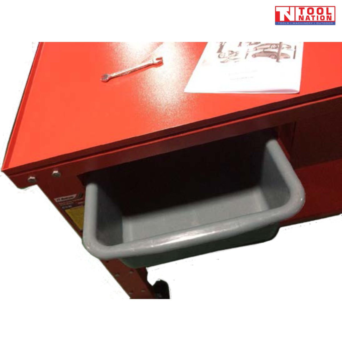 Close-up of grey removable tray under red workbench top