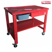 Angled front view of red mobile workbench with top tray, lower shelf, drawer, and castor wheels