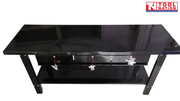 Angled view of black steel workbench with three drawers opened and lower shelf visible.
