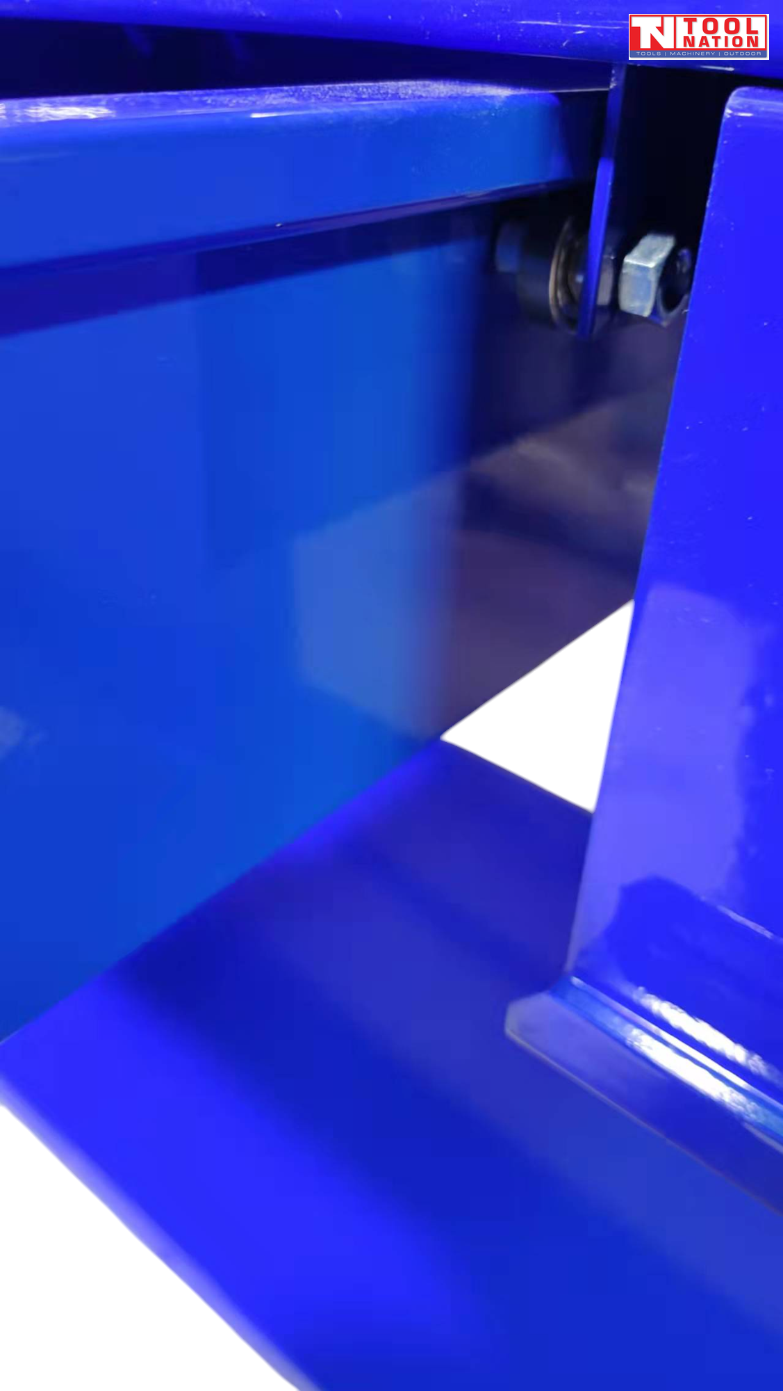 Close-up of side of blue workbench showing underside of drawer and lower shelf.