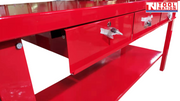 Close-up angled view of red workbench with one drawer partially open.