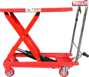 Red hydraulic lift table cart with raised scissor frame, handle, wheels, and warning label.
