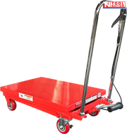 Red hydraulic lift table cart with lowered platform, chrome handle, wheels, and warning labels.