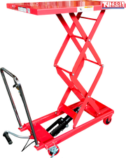 Red hydraulic lift table cart with raised double scissor frame, chrome handle, foot pedal, wheels, and labels.
