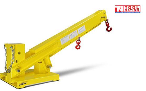Yellow forklift crane jib shown at an upward angle with two red swivel hooks, chain, base plate, warning labels and Tool Nation logo.