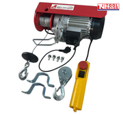 Angled view of a red electric hoist with cable drum, hooks, mounting brackets, bolts, power cord, and yellow pendant control.